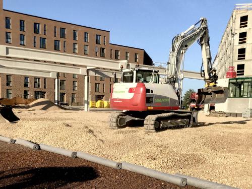 Excavator on a roof area filled with substrate